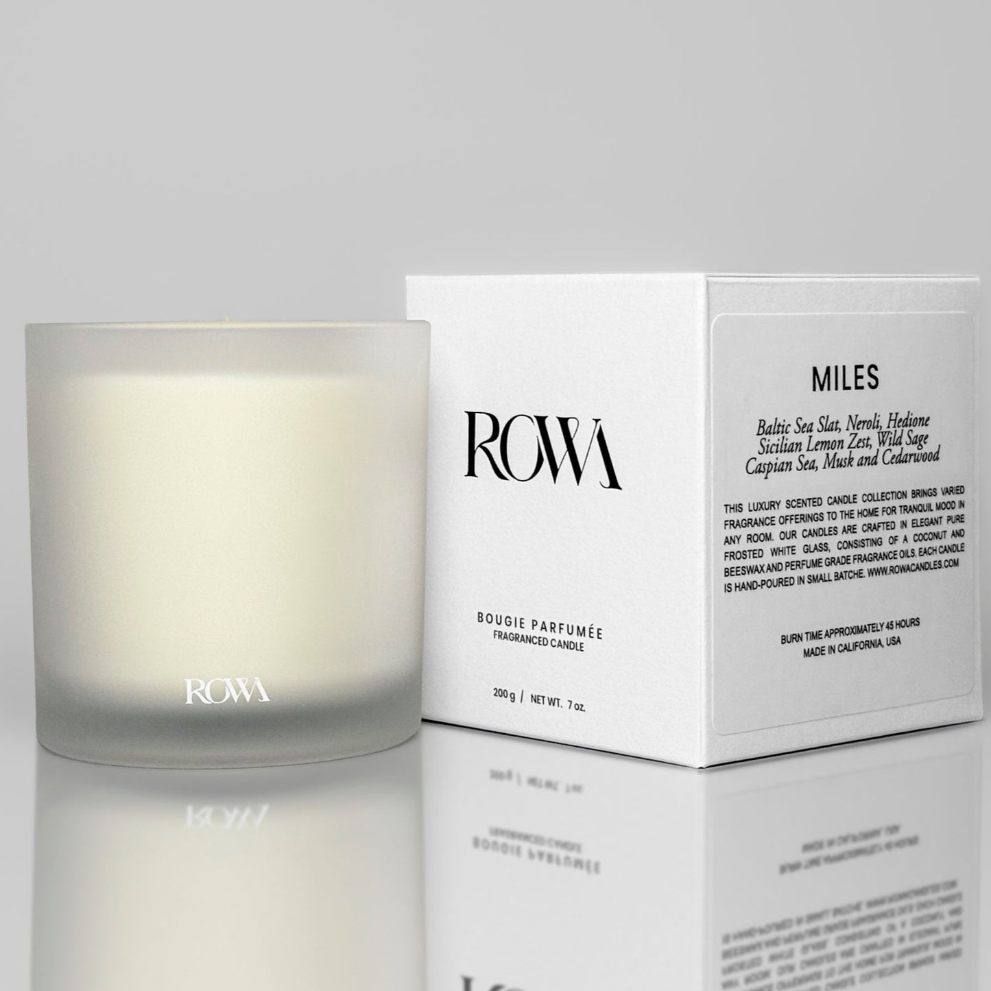 ROWA Miles candle in frosted glass, styled with coastal tones and summer light to reflect its ocean-inspired scent of sea salt and sage.