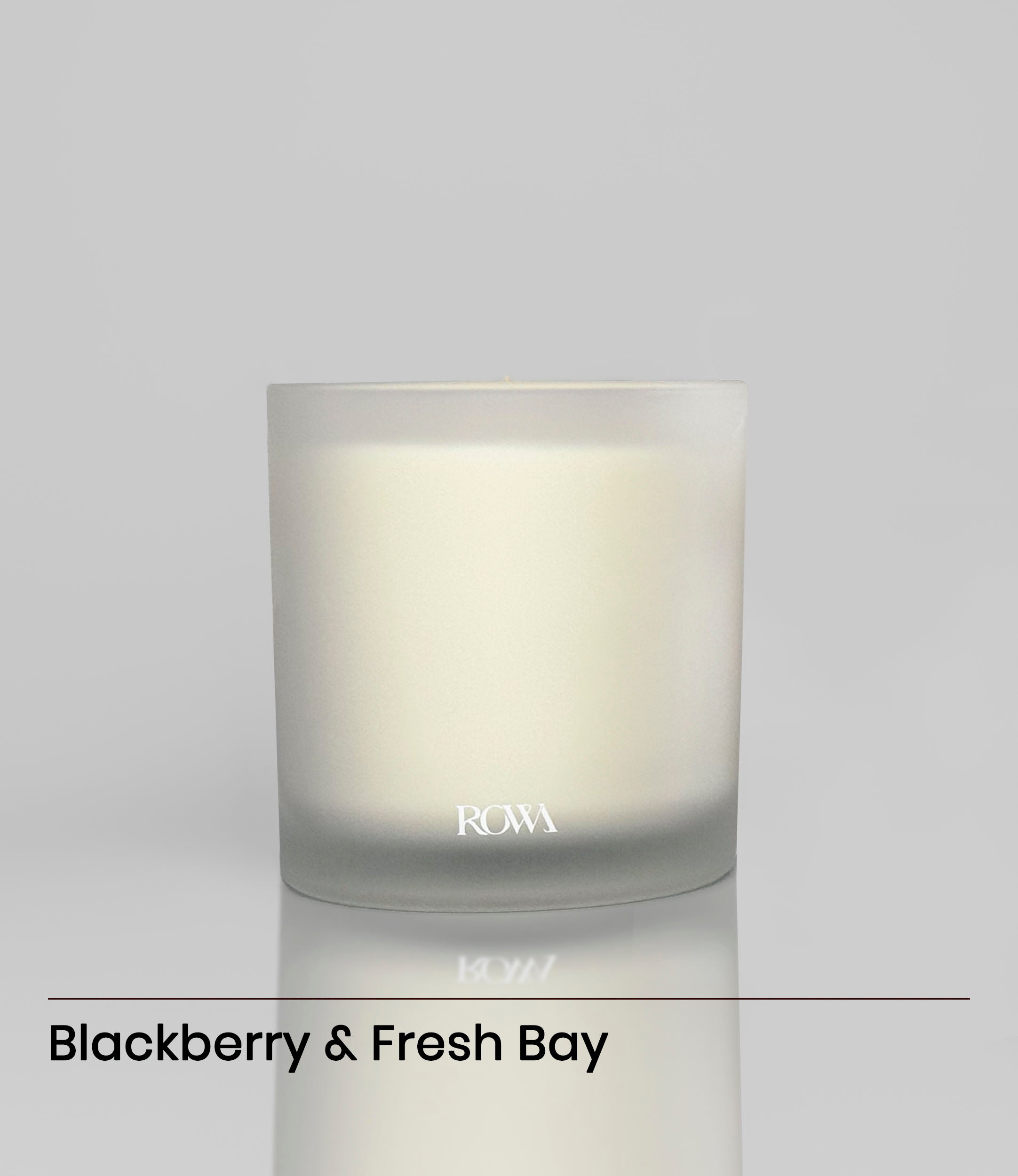 ROWA Berry Vine candle in frosted glass, styled with berries, green leaves, and warm wood tones to evoke a wild orchard atmosphere.

