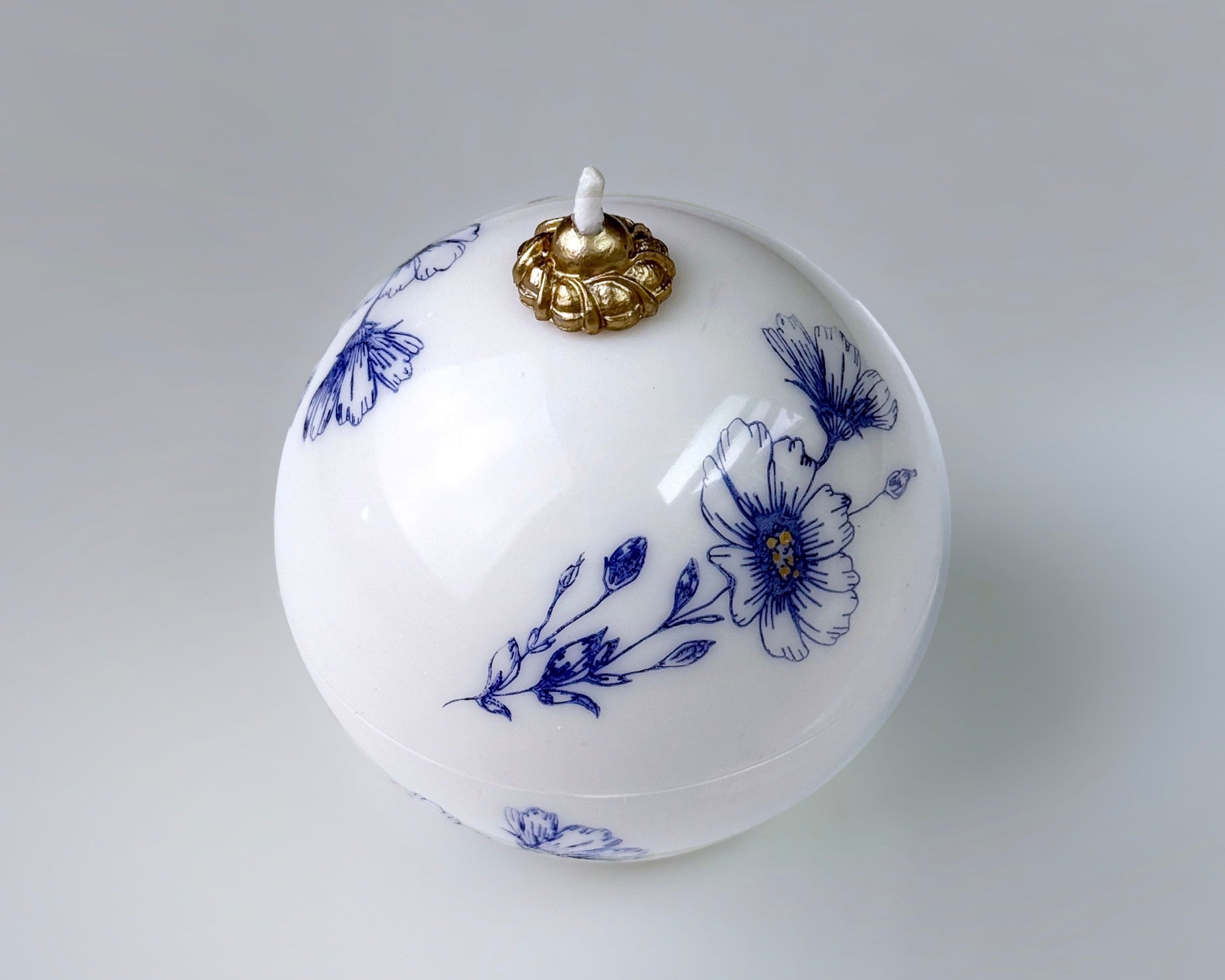 ROWA Dojaghee candle sculpted in beeswax with blue floral pattern and brass detail, inspired by Korean porcelain and filled with lavender scent.

